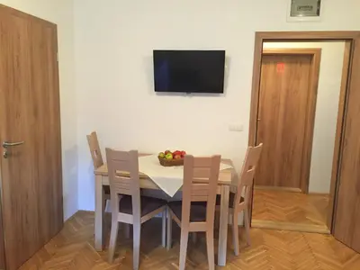 a dining room with a table with chairs and a bowl of fruit at Apartmaji in sobe Tina in Kranjska Gora