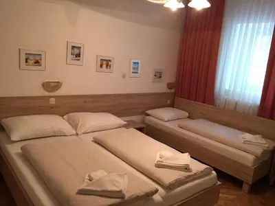two beds in a small room with a window at Apartmaji in sobe Tina in Kranjska Gora