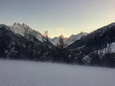 a view of a snowy mountain range with a lake at Apartmaji in sobe Tina in Kranjska Gora