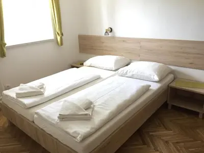 two beds with white pillows on them in a room at Apartmaji in sobe Tina in Kranjska Gora