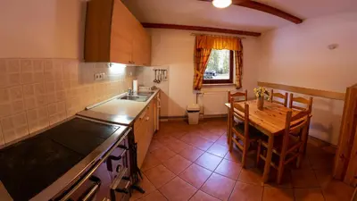 a kitchen with a table and a sink and a stove at Digital Detox Chalet Pokljuka in Goreljek