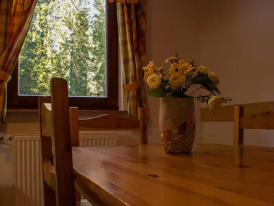 a vase of flowers sitting on top of a wooden table at Digital Detox Chalet Pokljuka in Goreljek