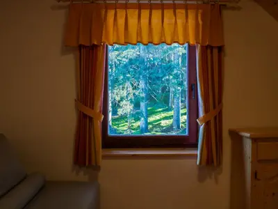 a window with orange curtains in a room at Digital Detox Chalet Pokljuka in Goreljek