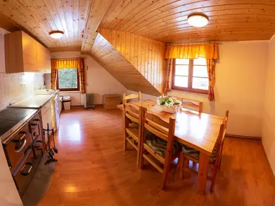 a kitchen and dining room with a wooden table at Digital Detox Chalet Pokljuka in Goreljek