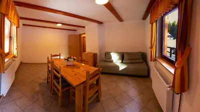 a living room with a table and a couch at Digital Detox Chalet Pokljuka in Goreljek