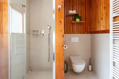 a bathroom with a toilet and a glass shower at Villa Harmonia Private Jacuzzi and Pool Retreat near Rogaška in Rogatec