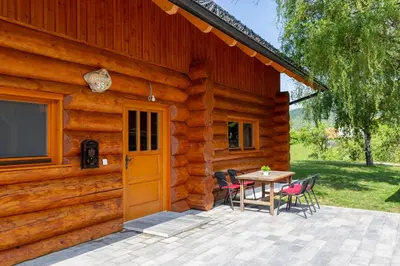 a wooden cabin with a table and chairs outside at Villa Harmonia Private Jacuzzi and Pool Retreat near Rogaška in Rogatec