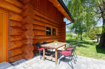 a wooden house with a table and chairs on a patio at Villa Harmonia Private Jacuzzi and Pool Retreat near Rogaška in Rogatec