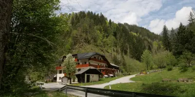 a building in the middle of a mountain at Guest House and Museum Firšt in Solčava