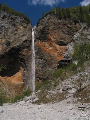 a waterfall on the side of a rocky mountain at Guest House and Museum Firšt in Solčava