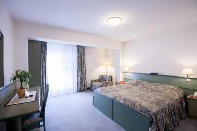 a hotel room with a bed and a desk and a window at Sobe Krona in Radovljica