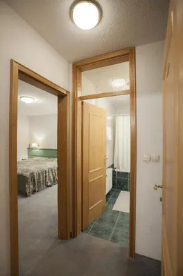 a room with a bed and a door leading to a bedroom at Sobe Krona in Radovljica