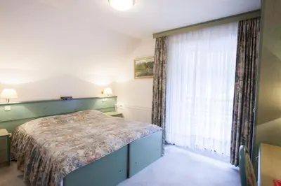 a bedroom with a bed and a large window at Sobe Krona in Radovljica