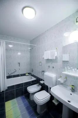 a bathroom with a toilet and a sink and a tub at Sobe Krona in Radovljica
