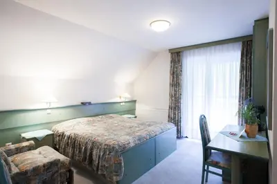 a bedroom with a bed and a table and a chair at Sobe Krona in Radovljica