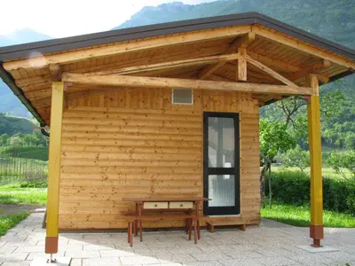 a wooden pavilion with a bench in front of it at Apartma Ferjan in Žaga