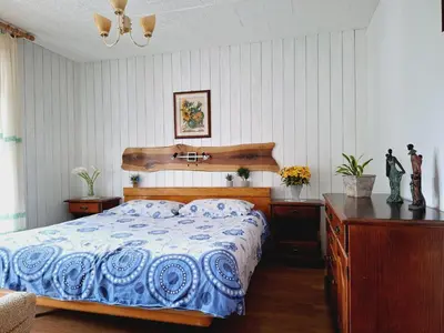 a bedroom with a blue and white bed and a desk at Apartma Ferjan in Žaga