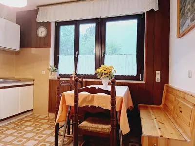a kitchen with a table with a vase of flowers on it at Apartma Ferjan in Žaga