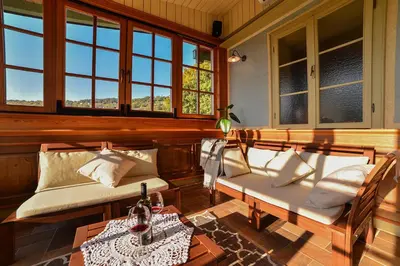 a porch with two chairs and a table and windows at Villa Les with Hot tub & Sauna in Brežice