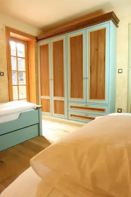 a bedroom with a bed and wooden cabinets at Villa Les with Hot tub & Sauna in Brežice