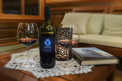 a bottle of wine and two glasses on a table at Villa Les with Hot tub & Sauna in Brežice