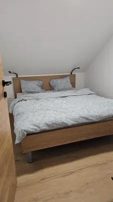 a bedroom with a wooden bed with two pillows at Apartment Kranjc in Cerknica