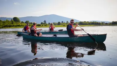 a group of people in a canoe on a lake at Apartment Kranjc in Cerknica