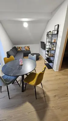 a living room with a table and yellow chairs at Apartment Kranjc in Cerknica