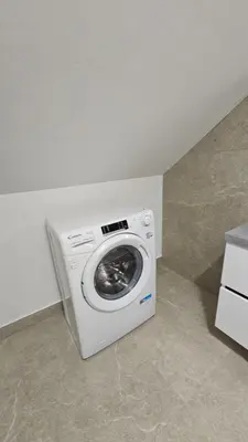 a washing machine in a corner of a room at Apartment Kranjc in Cerknica