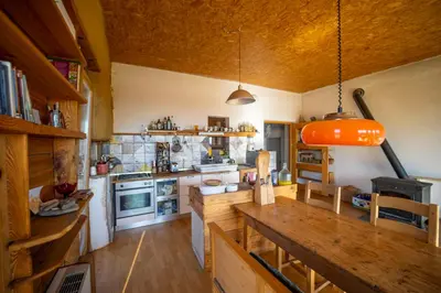 a kitchen with a large wooden table in a room at ELIAS Residency in Rob