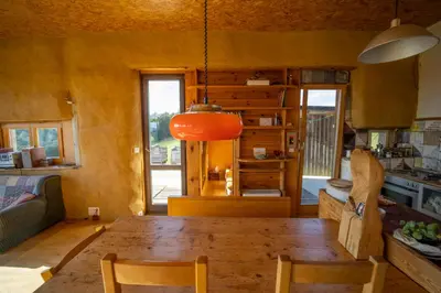 a dining room with a wooden table and a kitchen at ELIAS Residency in Rob