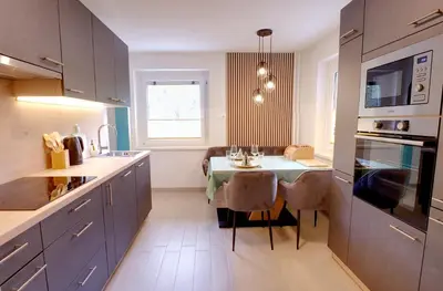 a kitchen with a table and a dining room at Apartma Pr'kovač in Bohinjska Bistrica