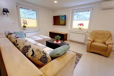 a living room with a couch and a chair at Apartma Pr'kovač in Bohinjska Bistrica