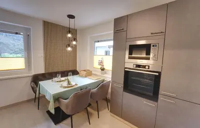 a kitchen and dining room with a table and a microwave at Apartma Pr'kovač in Bohinjska Bistrica