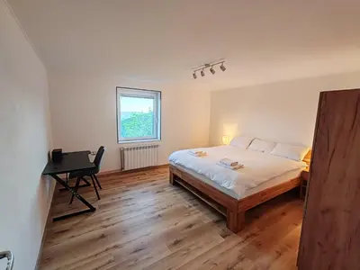 a bedroom with a bed and a desk in it at Apartments Stella Vittoria in Ročinj