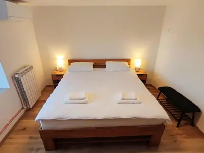 a bedroom with a large white bed with two lamps at Apartments Stella Vittoria in Ročinj