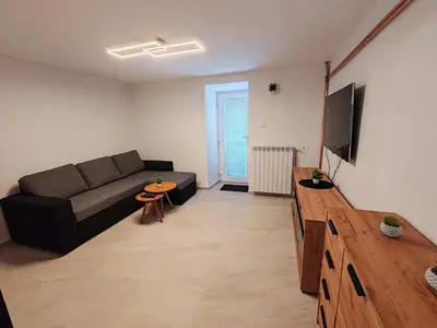 a living room with a couch and a flat screen tv at Apartments Stella Vittoria in Ročinj