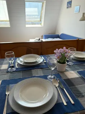 a table with plates and utensils on top of it at Apartma Lisjak in Bovec