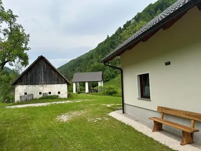 a bench sitting next to a building with a barn at Krtajse in Slappe dʼIdria