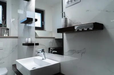 a white bathroom with a sink and a mirror at Apartma Lilly in Bohinjska Bela