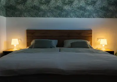 a bedroom with a large bed with two lamps at Apartma Lilly in Bohinjska Bela