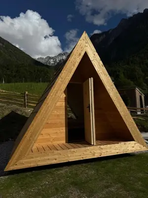 a frame tent with a door in the grass at Glamping Kamp Triglav in Soča
