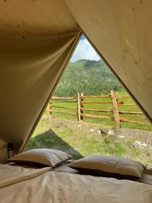 a tent with a view of a field and a fence at Glamping Kamp Triglav in Soča