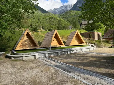 a group of houses with mountains in the background at Glamping Kamp Triglav in Soča