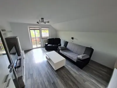 a living room with a couch and a table at Apartma Grm in Bohinj