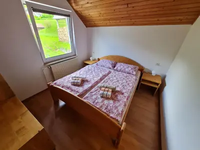 a small bedroom with a bed and a window at Apartma Grm in Bohinj