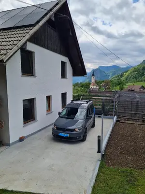 a car parked in a parking lot next to a house at Apartma Grm in Bohinj