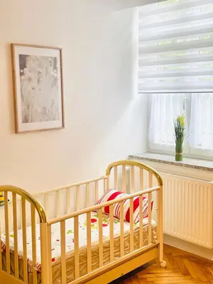 a crib in a room with a window at Topel dom v centru mesta 5 in Maribor