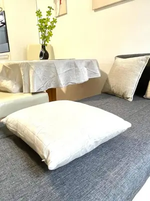 a white pillow sitting on a bed in a room at Topel dom v centru mesta 5 in Maribor