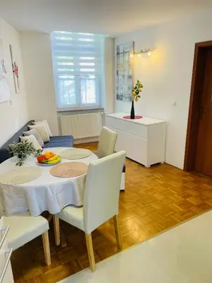a dining room with a table and chairs in a room at Topel dom v centru mesta 5 in Maribor